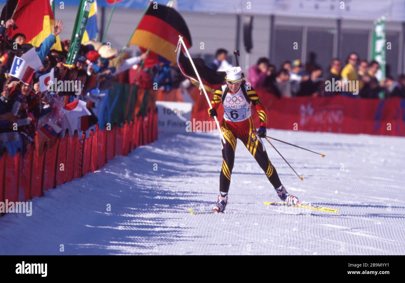 firo: 19.02.1998 Sport, Wintersport Olympia, Olympiade, 1998 Nagano, Japan, Olympische Winterspiele, 98, Archivbilder Biathlon, Frauen, Staffel 4x 7,5 km Staffel, Gold für Deutschland, Gold für deutsche Frauen Petra Behle, ganze Figur, laufen, Schlussläuferin, Jubilation, Jubel, mit deutscher Flagge, Flag und Nutzung weltweit Stockfoto