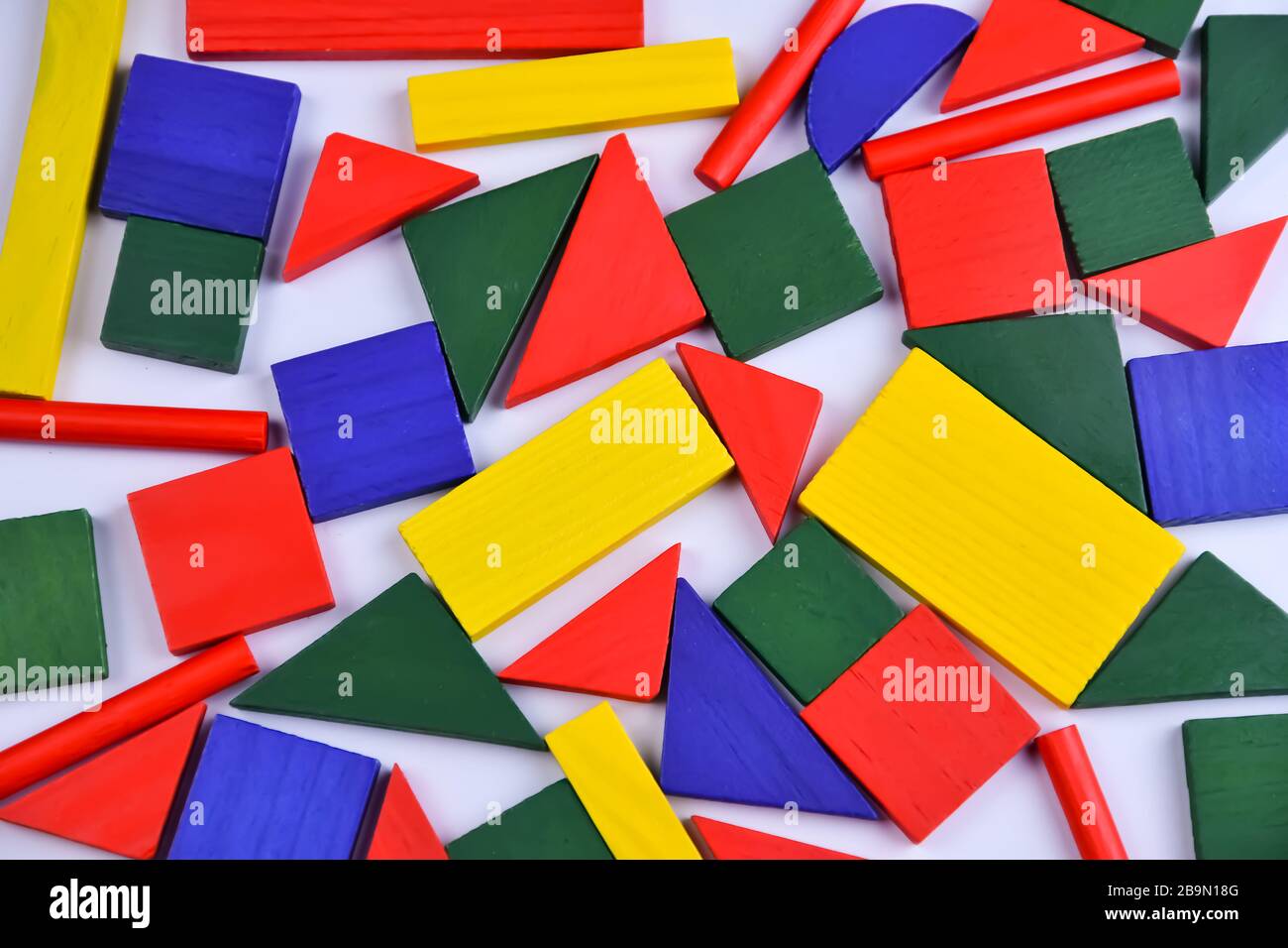 Mehrfarbiges Hintergrundbild kleiner geometrischer Holzfiguren verschiedener Farben Stockfoto