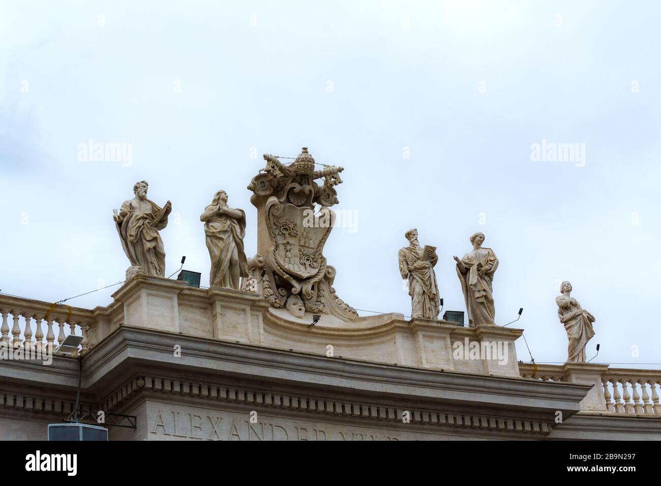 Statuen von Jesus, Aposteln und Heiligen im Petersdom und den Kolonnaden, Vatikanstadt, Details der Fassade außen auf trübem Himmel Hintergrund. Stockfoto