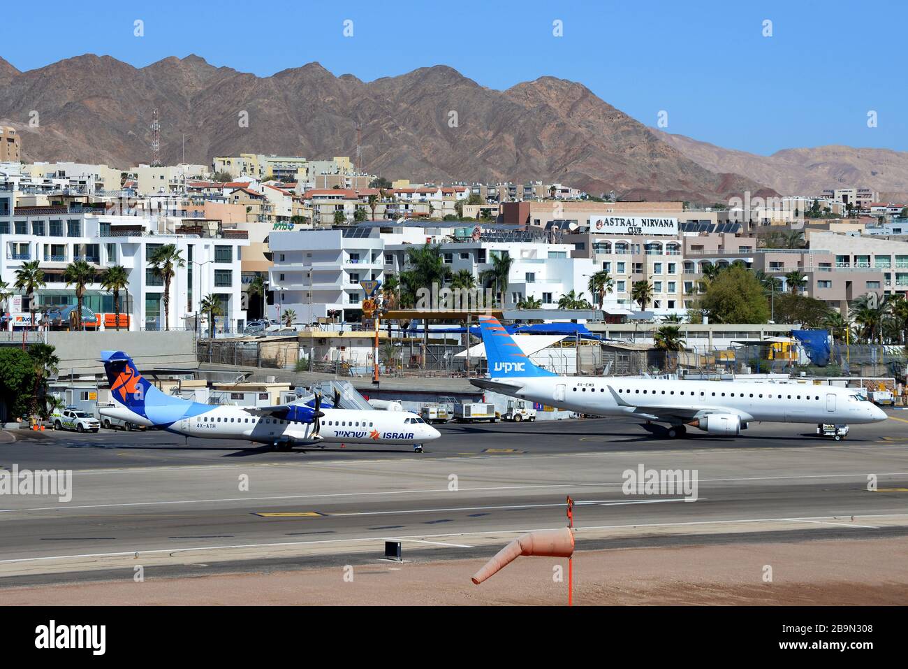 Alter Flughafen von Eilat (heute geschlossen) mit den Bergen dahinter. Israir ATR 72 und Arkia Israelis Airlines Embraer 195 parkten vor dem Terminal Stockfoto