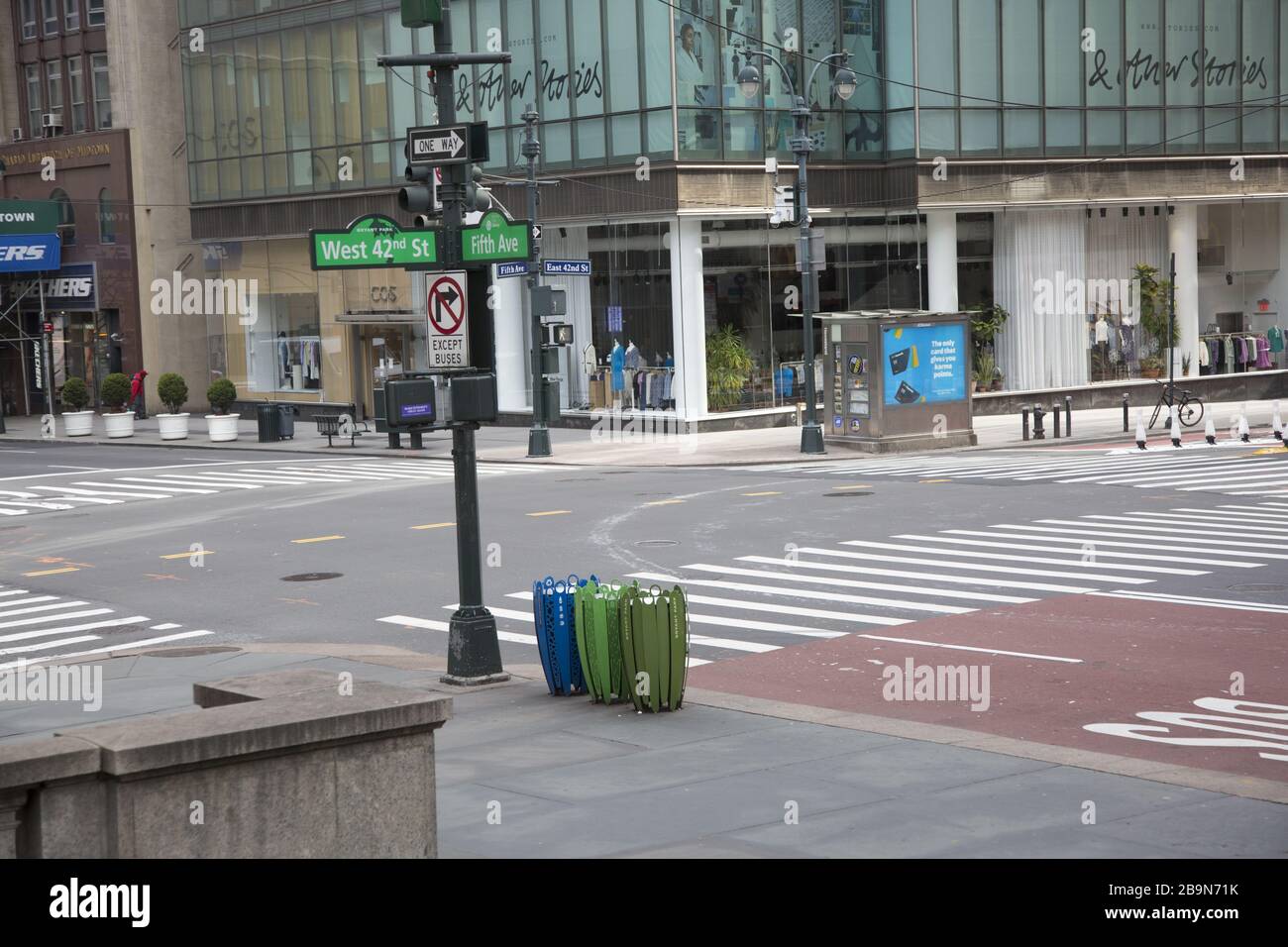 Die Ecke 5th Avenue und 42nd Street, einer der belebtesten Orte in New York City, ist aufgrund der Coronavirus Pandemie und der offiziellen "Sperrung" der Stadt praktisch leer. Stockfoto