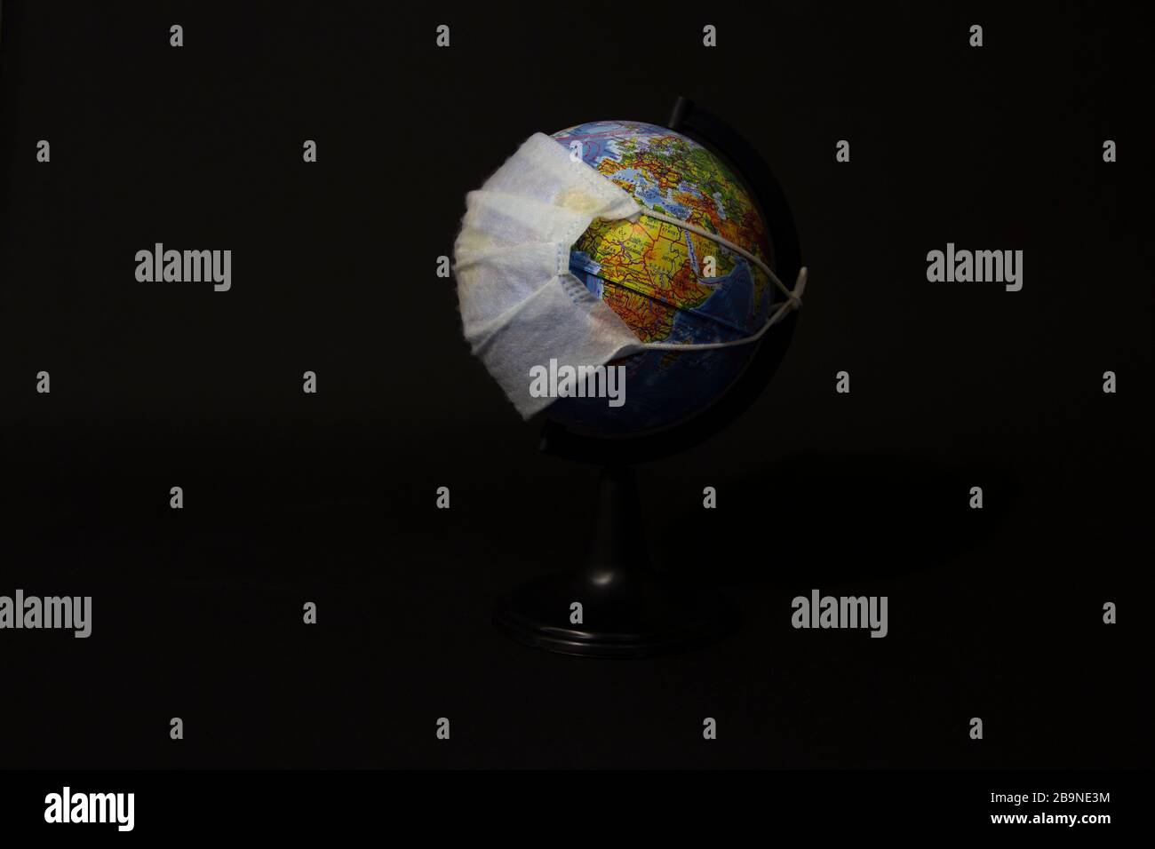 Globus in einer chirurgischen Maske, Sicherheitsmaske, Konzept einer globalen Pandemie oder Epidemie auf schwarzem Hintergrund Stockfoto