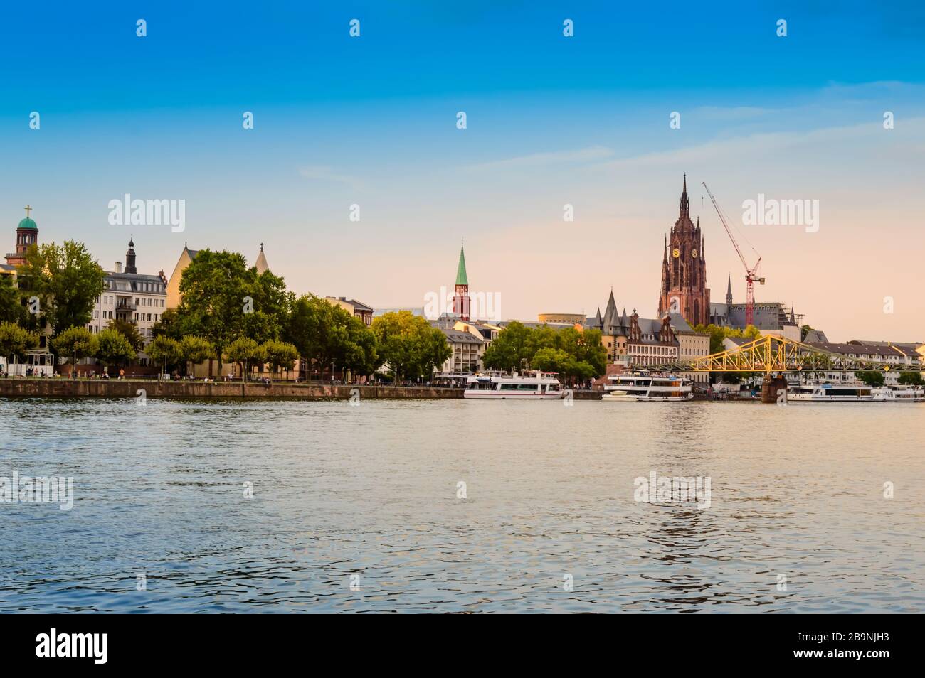 Historische Altstadt von Frankfurt am Main. Hafengebiet mit gotischer Kathedrale St. Bartholomäus, Promenade, Touristenbooten und Eiserner Steg i Stockfoto