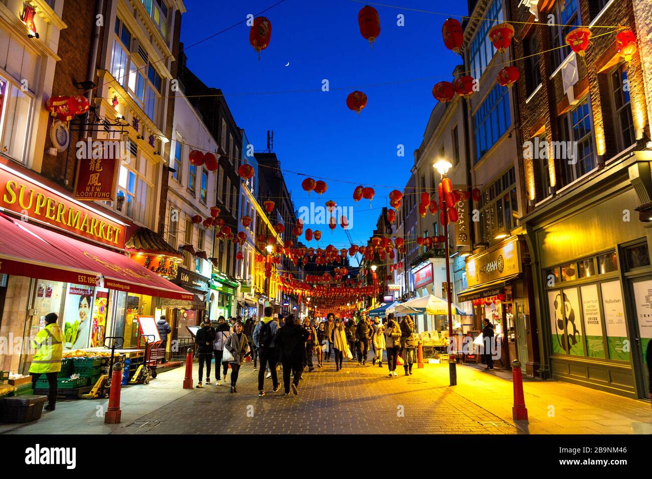 Rote und gelbe chinesische Laternen hängen nachts in China Town, London, Großbritannien über einer Straße Stockfoto
