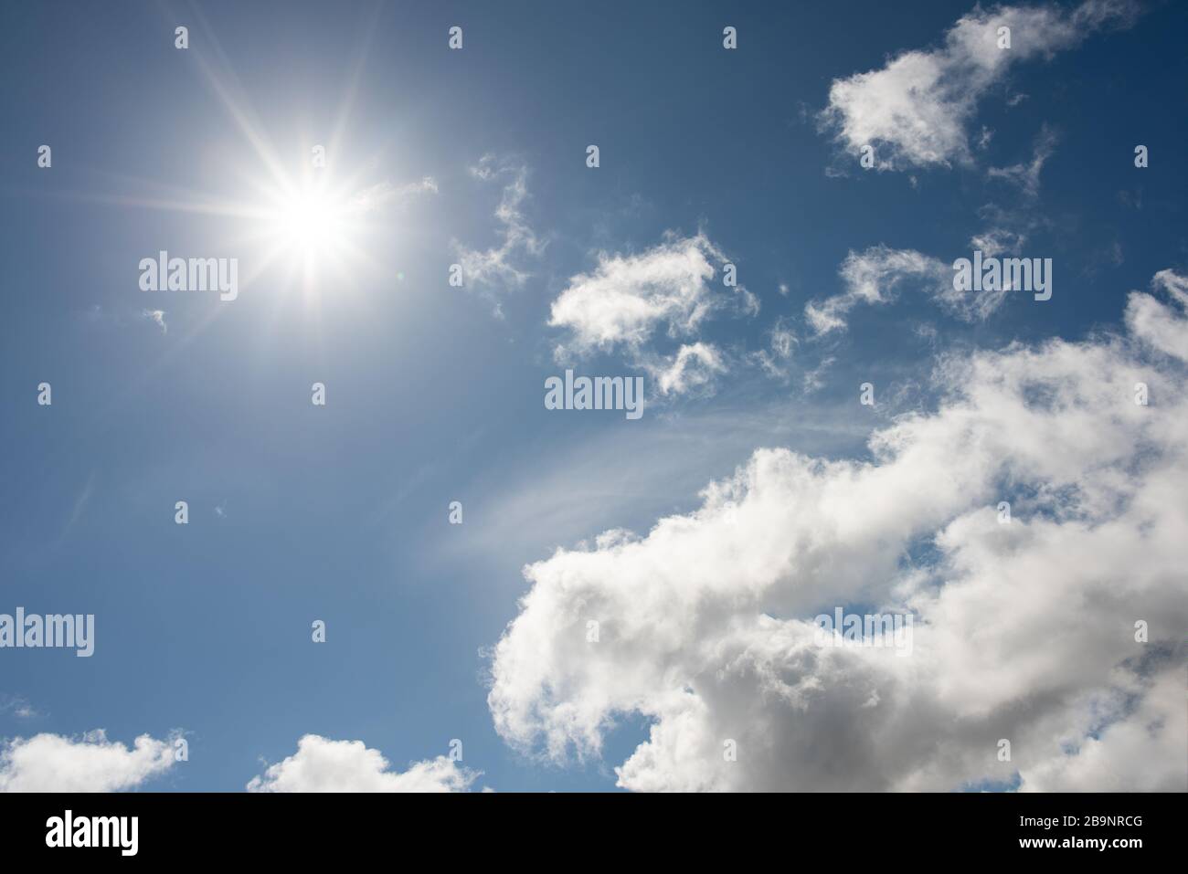 Wettervorhersage leicht bewölkte Sturmwolken bestahlen den blauen Himmel mit Sonnenschein Stockfoto