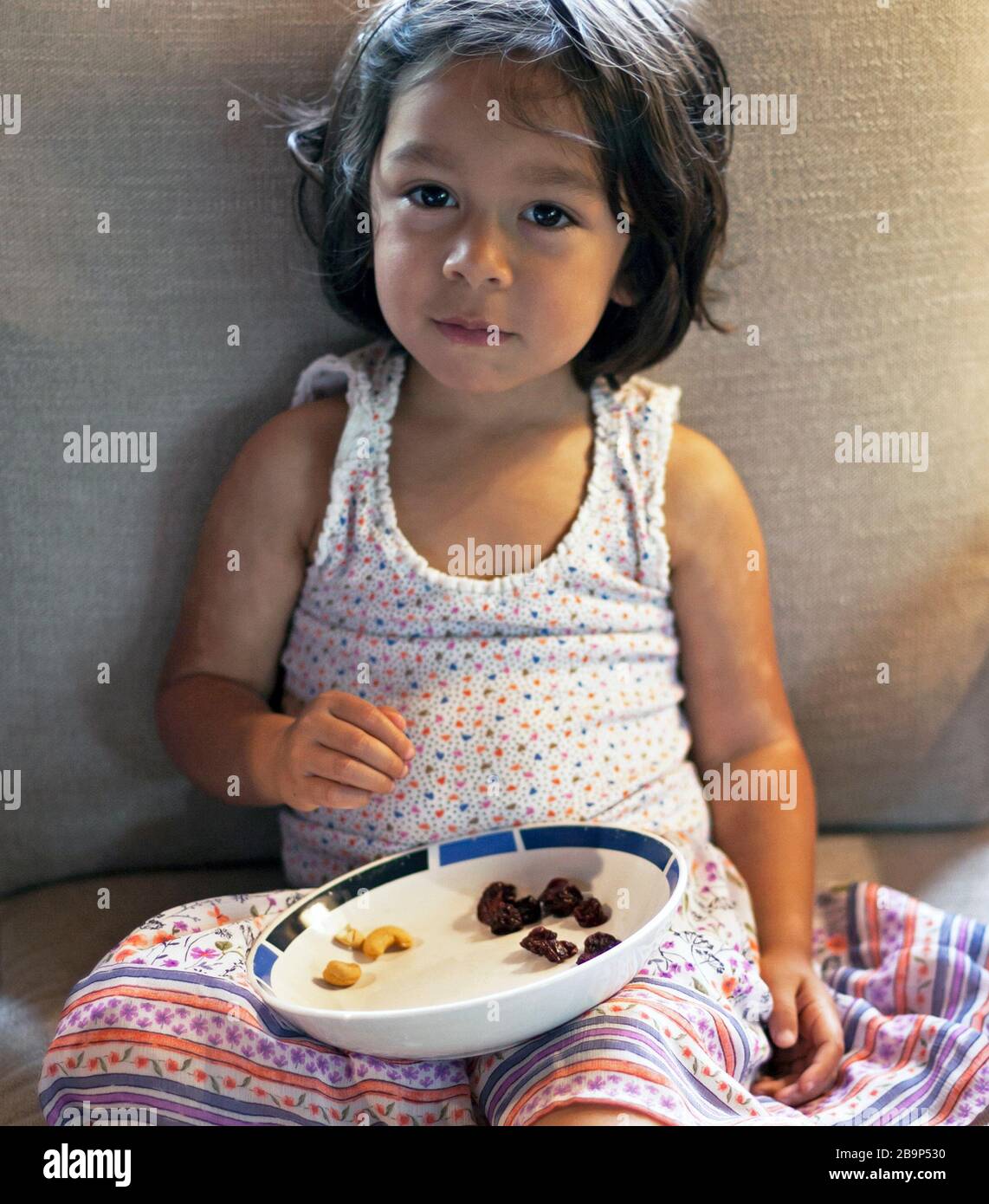 Ein 3-jähriges Mädchen isst im Urlaub ihren Imbiss. Stockfoto