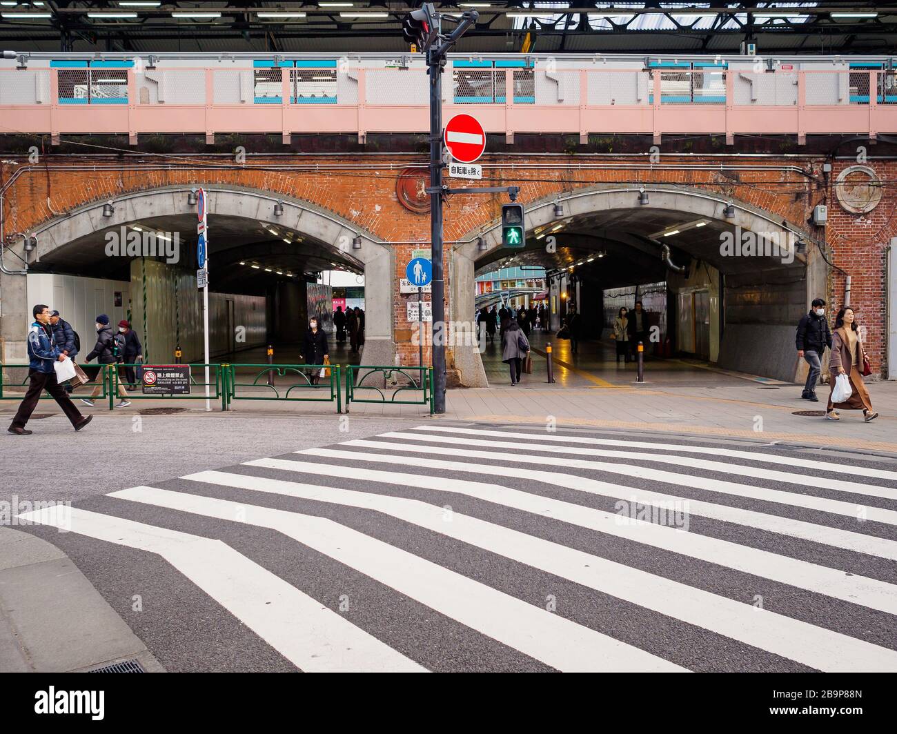 Eisenbahnbögen und Fußgängerüberweg am Bahnhof Yurakucho, Tokio, Japan. Stockfoto