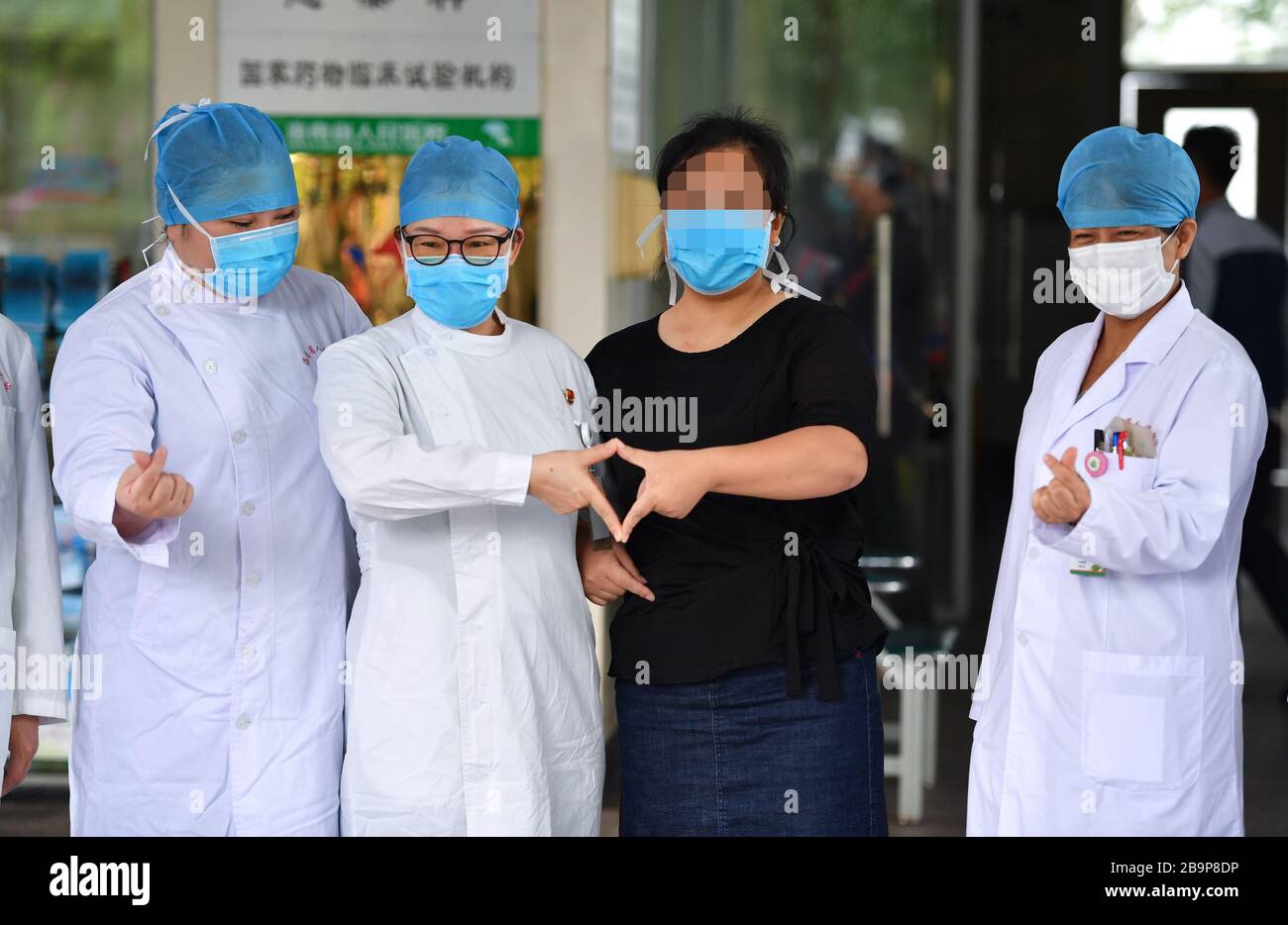 Peking, Chinas Provinz Hainan. März 2020. Die gehärtete COVID-19-Patientin Zeng (2. R) posiert für ein Foto mit medizinischem Personal im Hainan General Hospital in Haikou, Südchinesische Provinz Hainan, 24. März 2020. Die südchinesische Inselprovinz Hainan hat am Dienstag ihre Zahl der Fälle der neuartigen Coronavirus-Krankheit (COVID-19) auf Null reduziert. Nach der Genesung wurde der letzte COVID-19-Patient in der Provinz, eine 40-jährige Frau namens Zeng, gegen 9:00 Uhr morgens aus dem Hainan General Hospital entlassen Credit: Guo Cheng/Xinhua/Alamy Live News Stockfoto