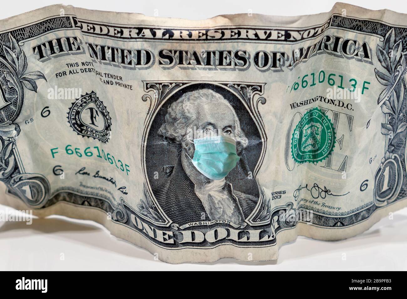 COVID-19 Coronavirus in den USA, eine amerikanische Dollarbanknote mit Gesichtsmaske. Stockfoto