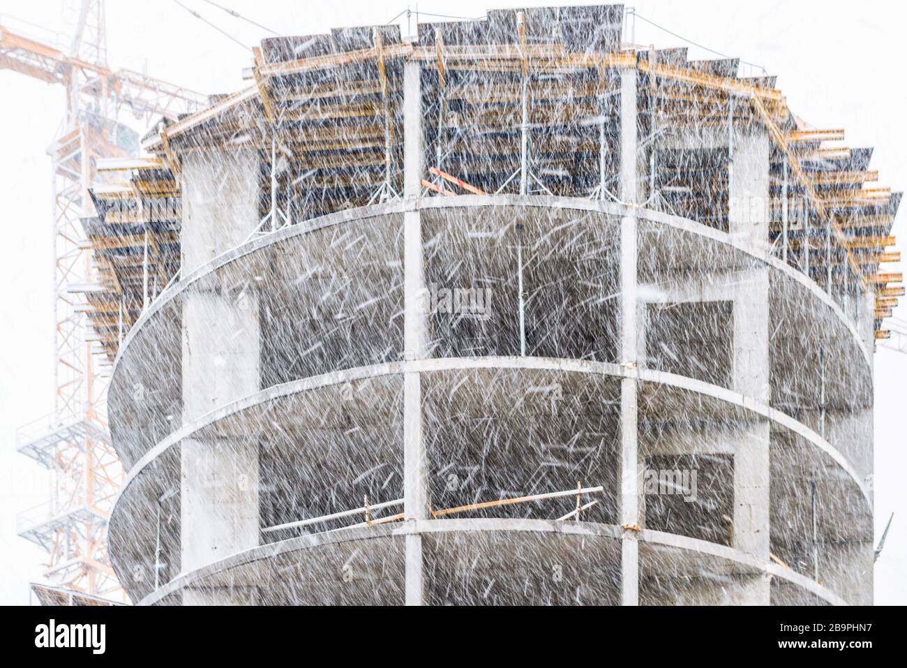 Schneefall im März. Fragment eines in Bau befindlichen Neubaus und Baustelle eines Wohnhauses in Kiew, Ukraine. Stockfoto