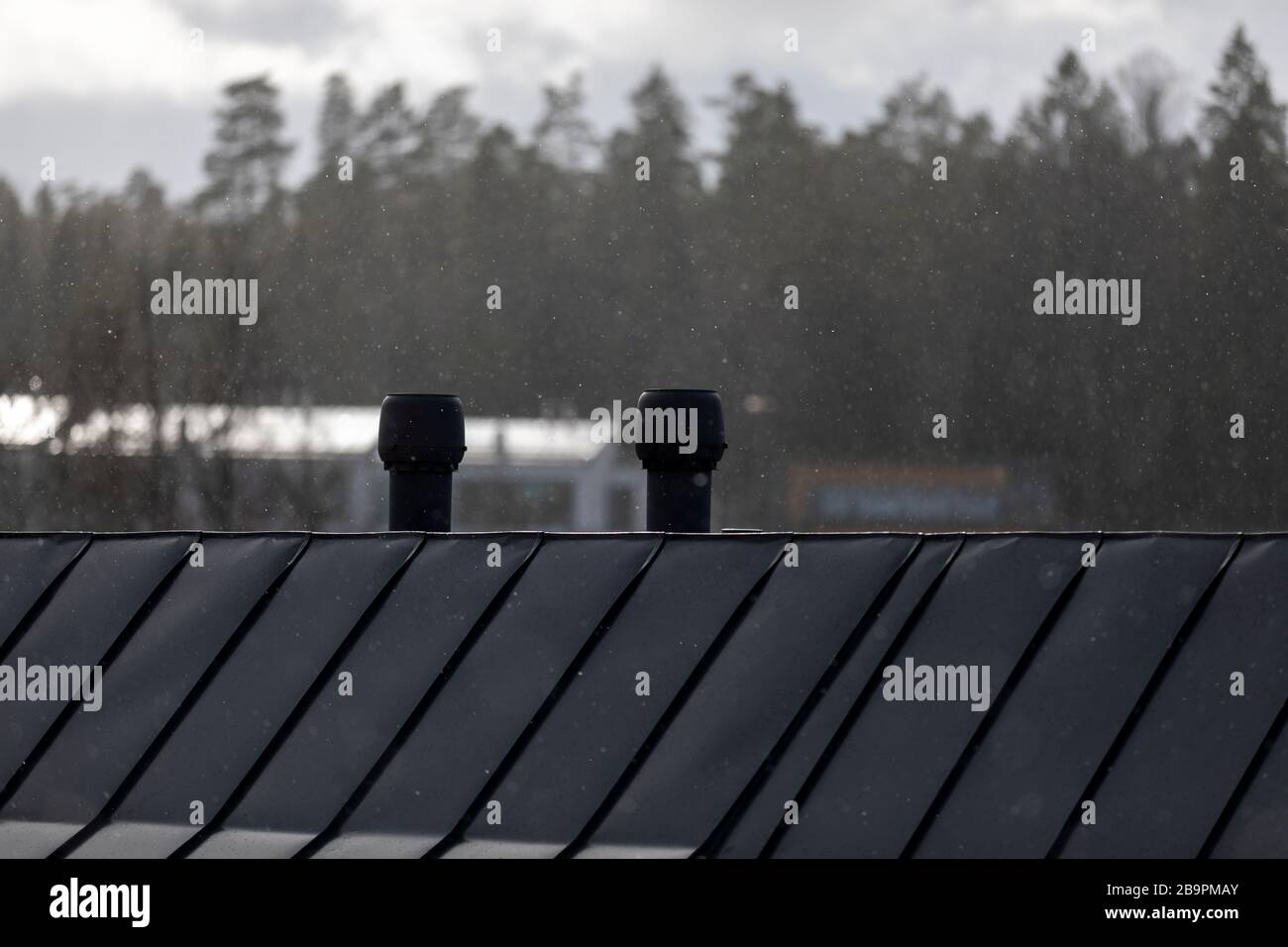 Leichter Schneefall und Dächer im finnischen Frühling ohne Menschen Stockfoto