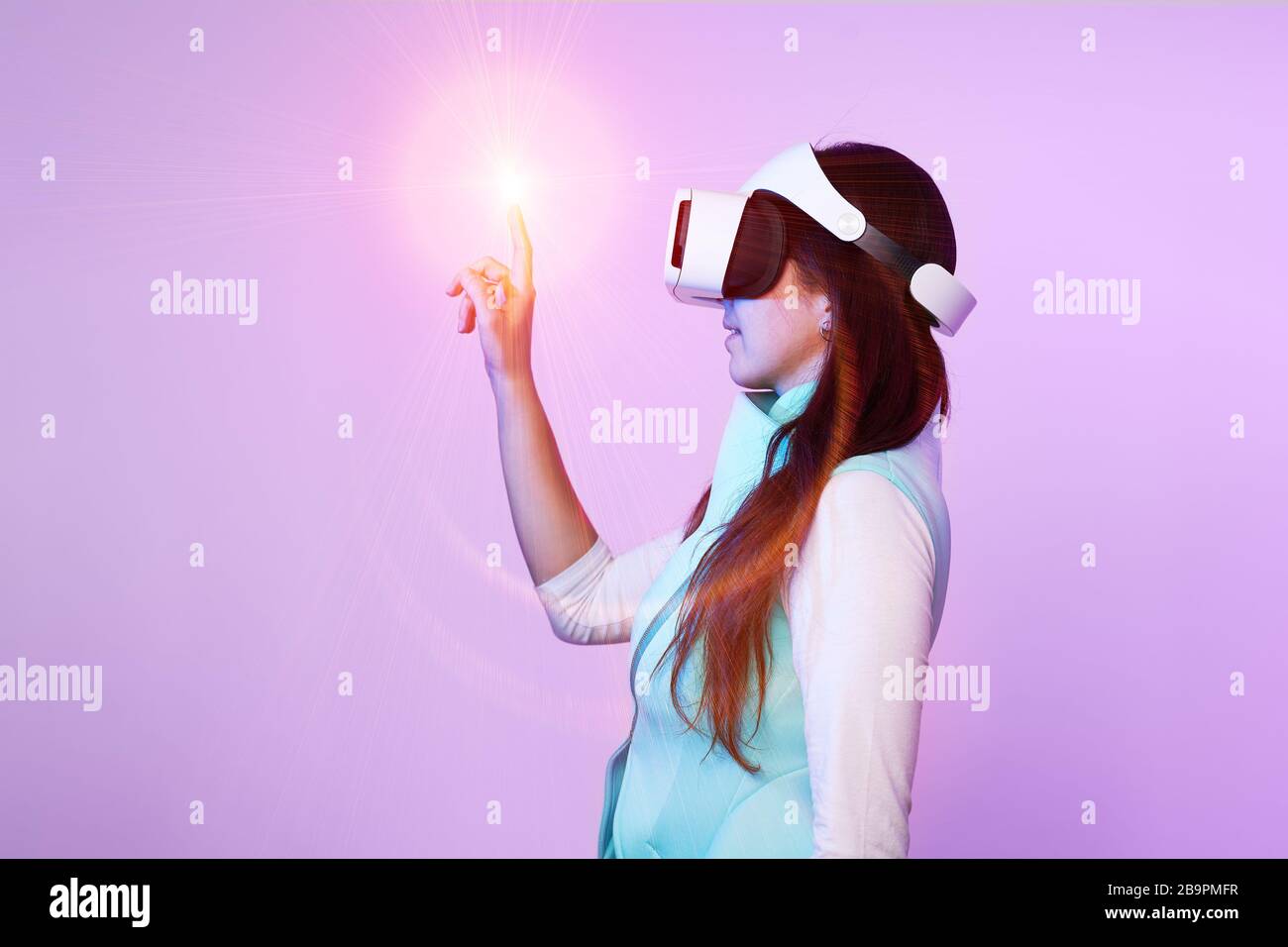 Frau mit Virtual reality Headset. Konzept der virtuellen Realität, Spiele, Unterhaltung und Kommunikation. Bild in der modernen Neon farbe Gamma. Stockfoto