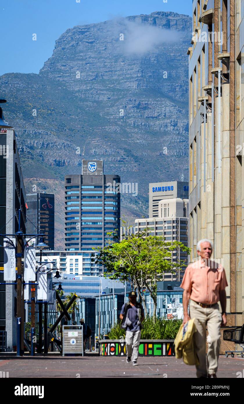 Männer, die im Finanzviertel der Stadt arbeiten, mit Büroblöcken und Tafelberg für die Kulisse, selektiver Fokus Kapstadt Südafrika Stockfoto