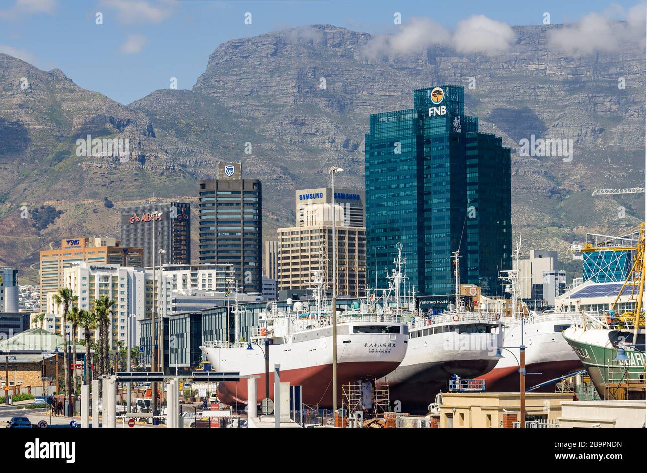 3 große asiatische Schiffe im Trockendock im Alfred-Becken-Reparaturdock-Yard Silo-Distrikt mit Stadt- und Tafelberg Backgroundhafen von Kapstadt Südafrika Stockfoto