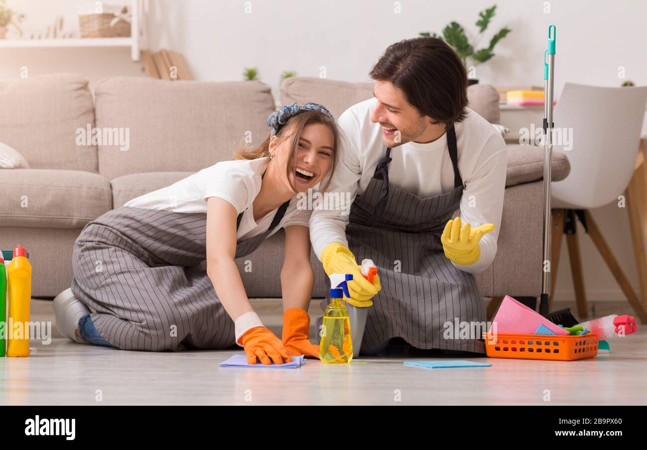 Spring-Clean. Junge Paare Haben Spaß Beim Reinigen Des Hauses, Waschen Boden Zusammen Stockfoto