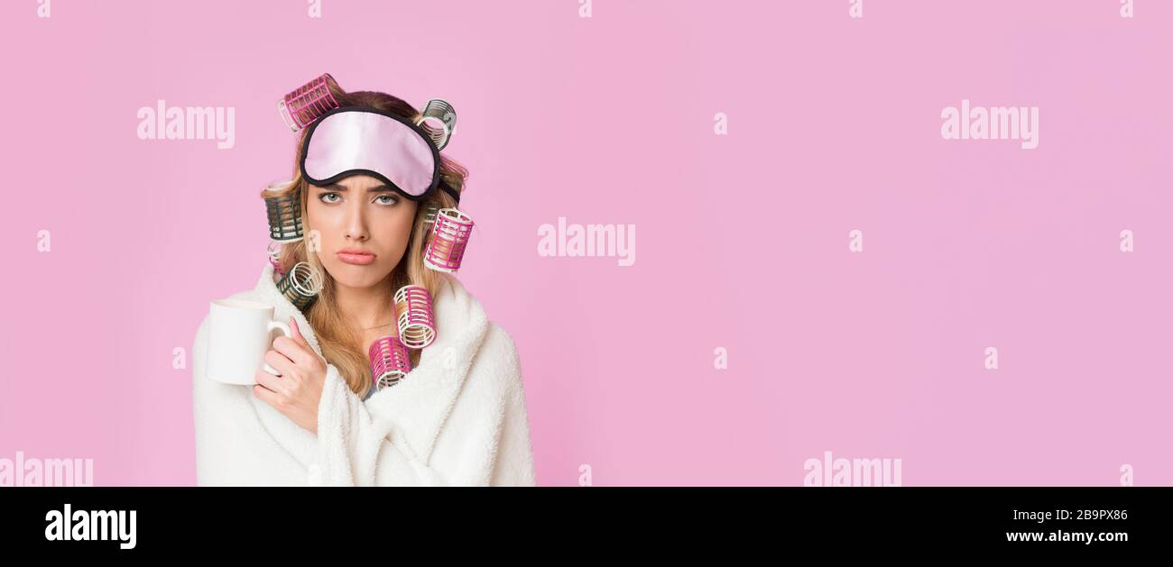 Trauriges Mädchen in Decke und mit Lockenstab wachte auf Stockfoto