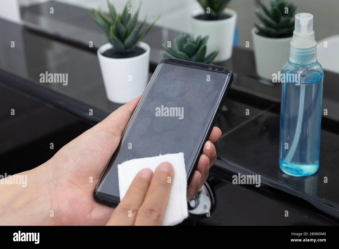 Desinfizieren, desinfizieren, hygienisch pflegen. Fingerabdruck auf dem Touchscreen des Mobiltelefons reinigen zur Desinfektion, Vermeidung von Keimen, die sich bei Infektionen ausbreiten Stockfoto