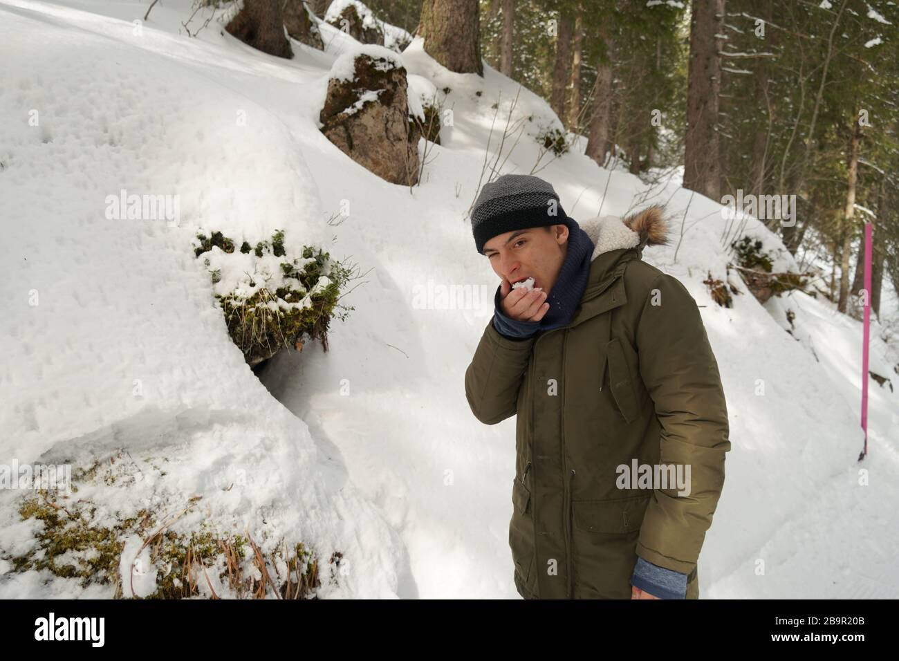 Herausforderndes Verhalten eines Teenagers mit autistischer Spektrumsstörung. Er frisst Schnee, auch wenn er ihm gesagt hat, es nicht zu tun. Stockfoto