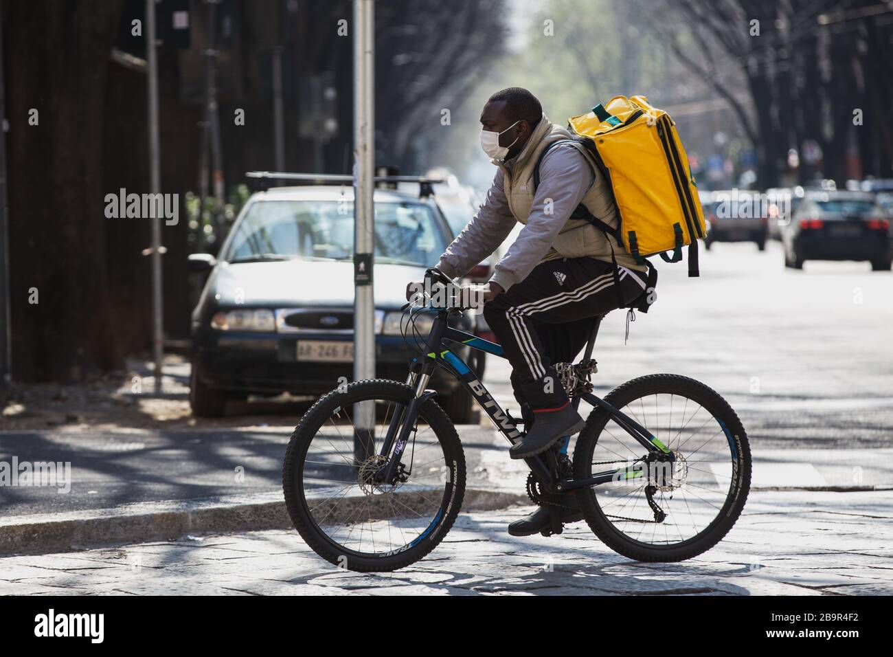 Food Delivery Man On Bike Arbeitet Mit Protection Mask Während Coronavirus Lockdown In Italien Stockfoto