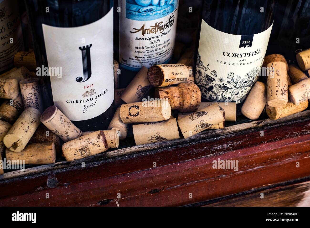 Athen, Griechenland - 18. Februar 2020. Flaschen Wein und alte gebrauchte Korkenstecker aus verschiedenen Weinerzeugerländern in einem Schaufenster Stockfoto