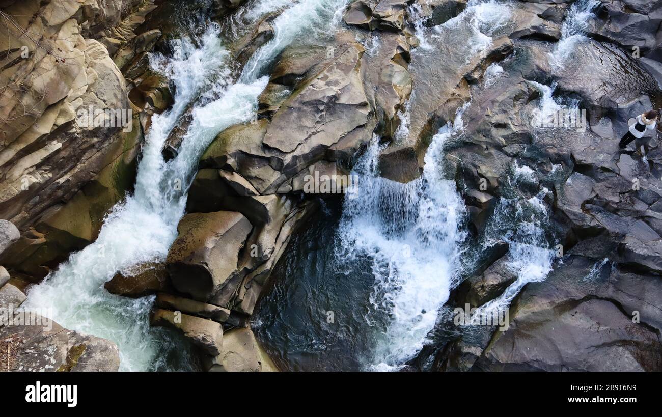 Wasserfall von oben nach unten. Von oben auf den Bach fließt Wasser über die Steine. Felsiger Bergwasserfall. Landschaft Berge felsiger Kaskadenfluss Stockfoto