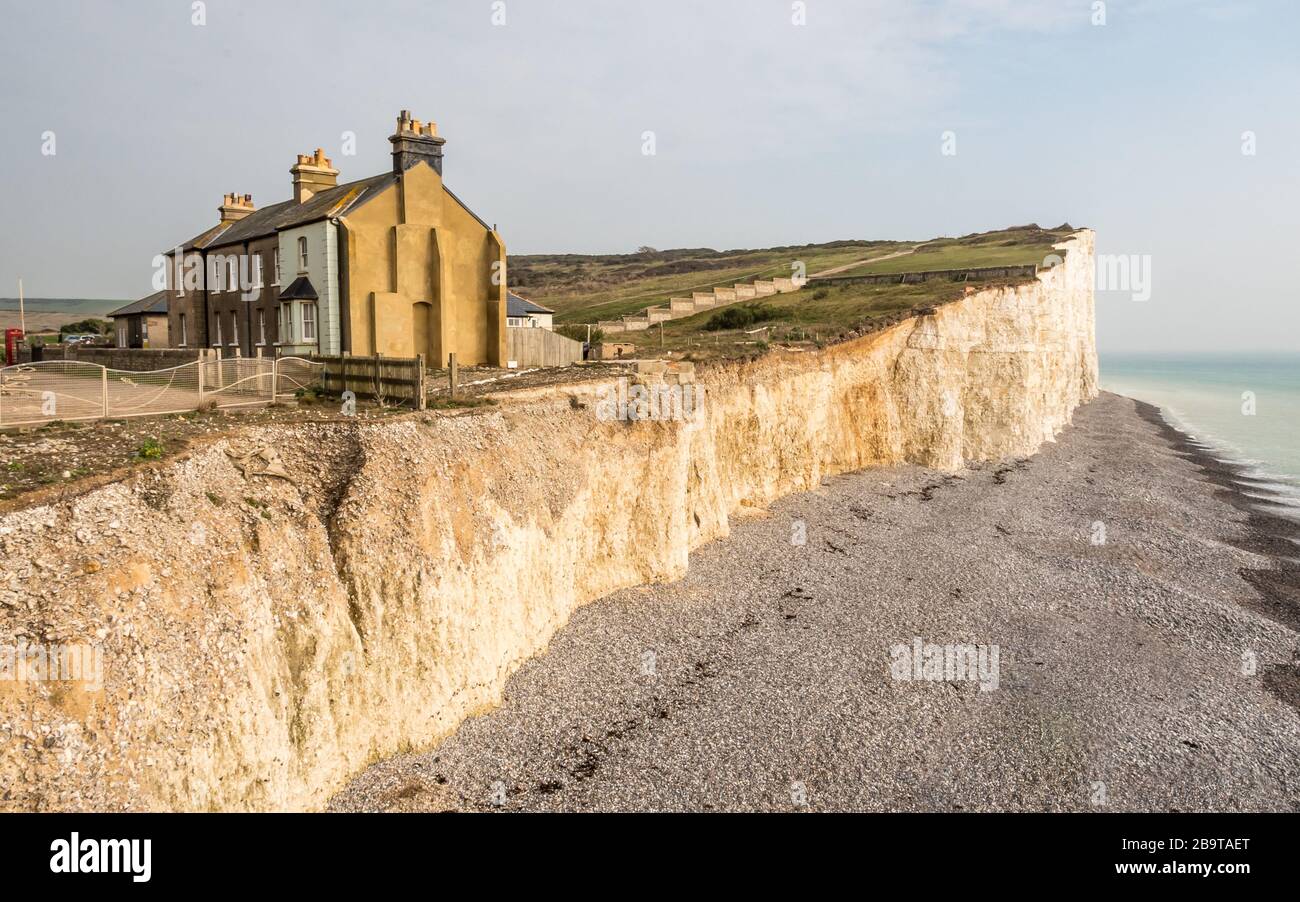 Küstenerosion, Sussex, Großbritannien. Eine abnehmende Reihe von Reihenhäusern, die die Auswirkungen des Wetters auf die Kreidefelsen im Süden Englands zeigen. Stockfoto