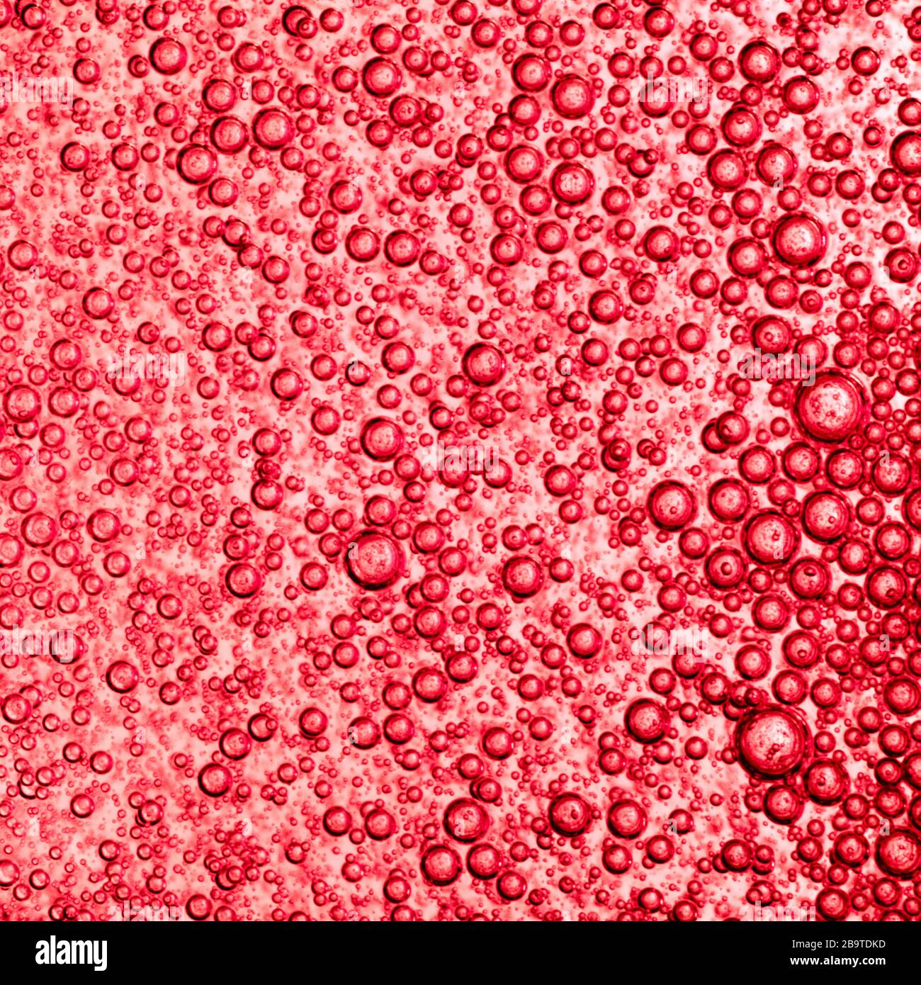 Luftblasen in roten Flüssigkeit Textur. Stockfoto