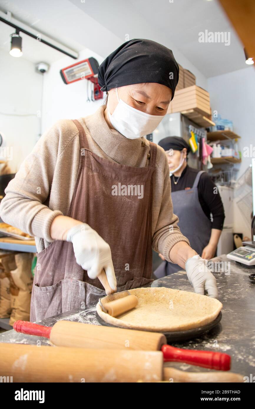 Frau, die während der Coronavirus-Pandemie in Seoul, Südkorea, eine Pastete in Biscotti und Pie Bakery backt Stockfoto