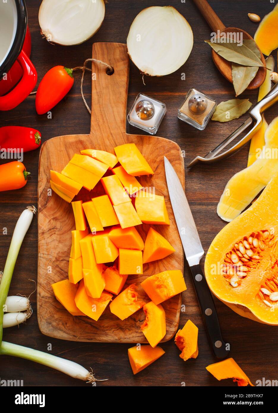 Vorbereitung von Kürbis, Zwiebeln und Paprika zum Kochen auf Holzbrett Stockfoto