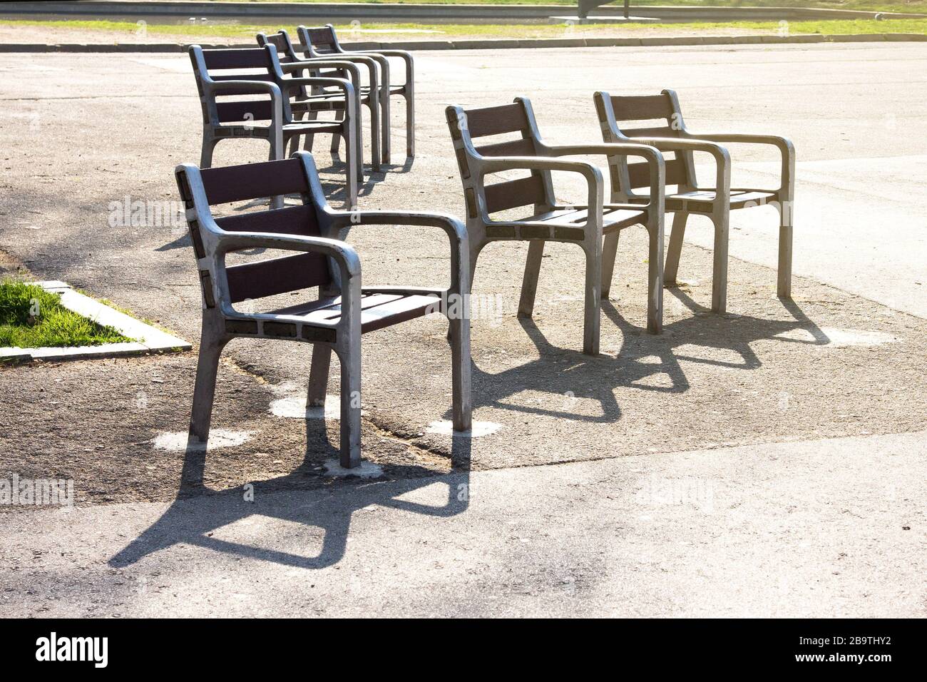 Leere Stühle im Morgenlicht. Stadtpark. Barcelona, Spanien. Quarantäne, nachdem die spanische Regierung beschlossen hatte, das ganze Land auf eine Reduzierung zu beschränken Stockfoto