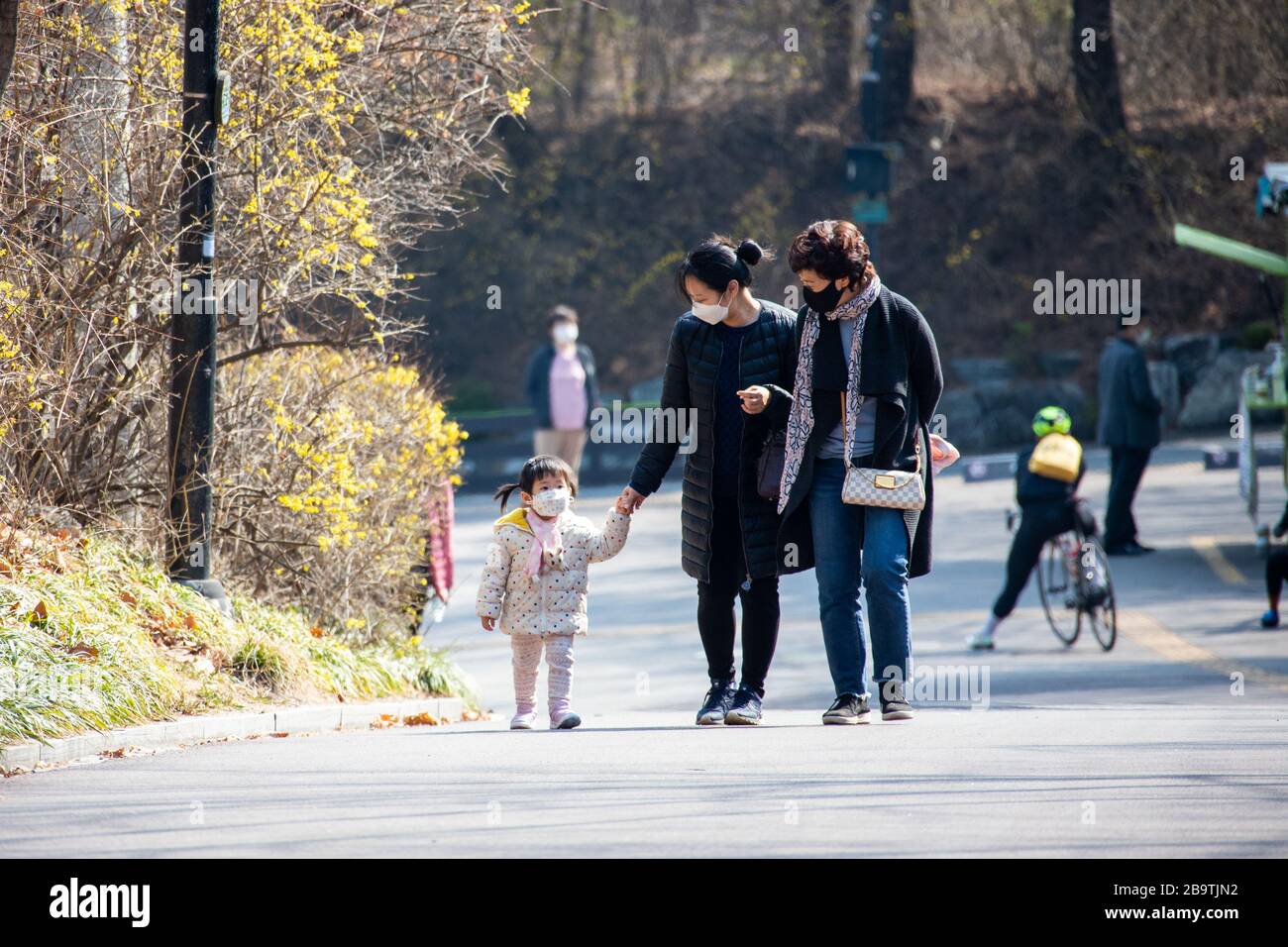 Junge Mädchen und Eltern, die während der Coronavirus Pandemie, Seoul, Südkorea, Gesichtsmasken tragen Stockfoto