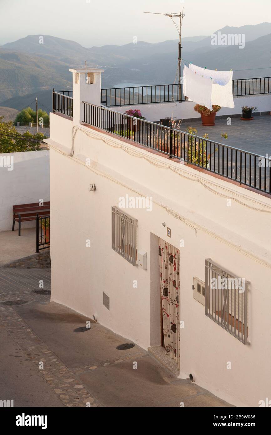 Ein Haus mit Wäsche-Trocknung auf einer Waschanlage auf der Dachterrasse und Blick über Rules Reservoir, Cañar, Granada, Spanien Stockfoto