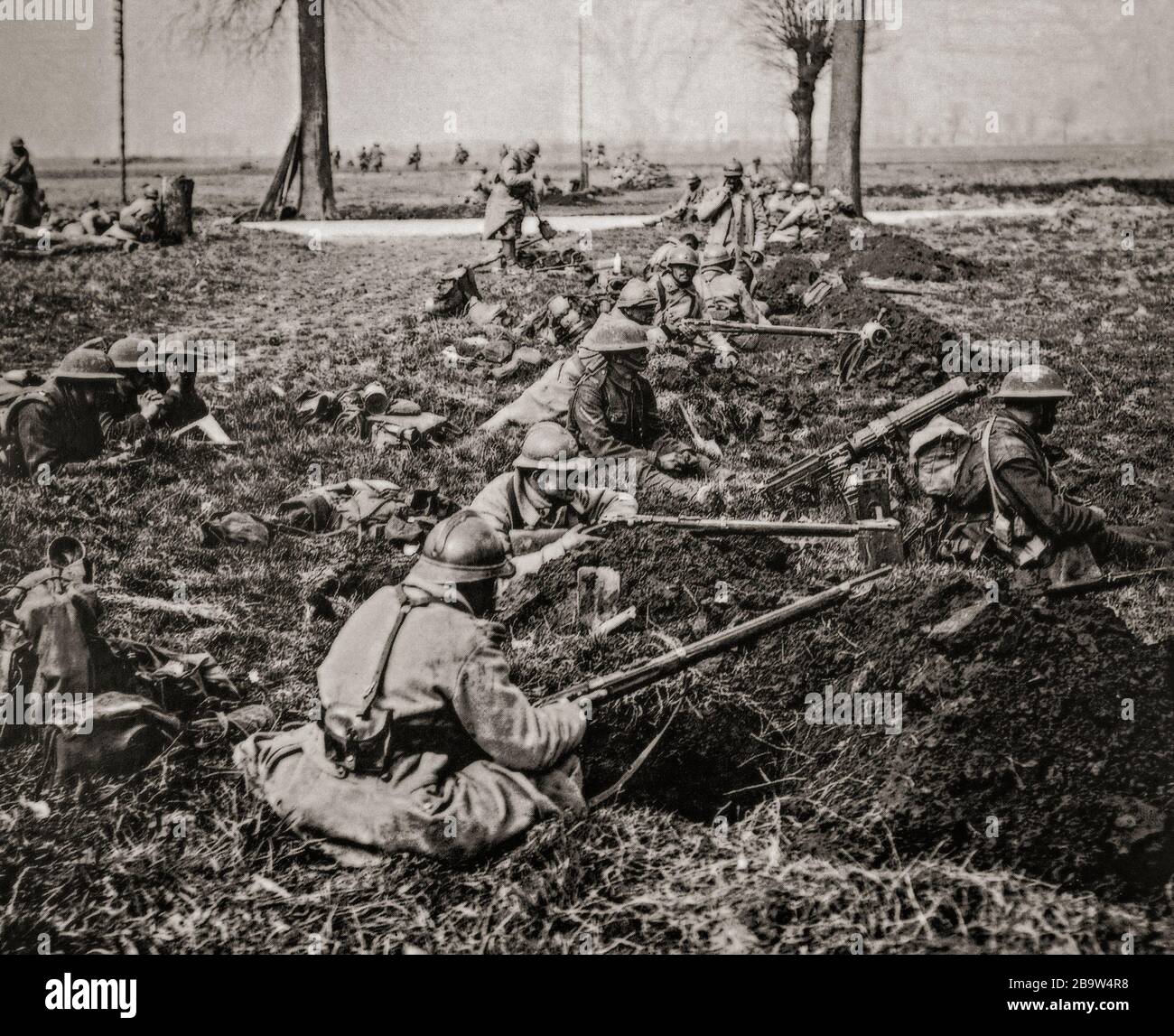 Britische und französische Truppen in Gewehrgruben, die eine Straße in der Nähe von Nesle während der Operation Michael bedeckten, die die deutsche Frühjahrsoffensive am 21. März 1918 begann. Sie wurde von der Hindenburg-Linie in der Nähe von Saint-Quentin in der Nähe von Cambrai, Frankreich, gestartet. Ihr Ziel war es, die Linien der Alliierten (Entente) zu durchbrechen und in nordwestlicher Richtung vorzurücken, um die Kanalhäfen zu beschlagnahmen, die die British Expeditionary Force (BEF) versorgten und die BEF ins Meer trieben. Stockfoto
