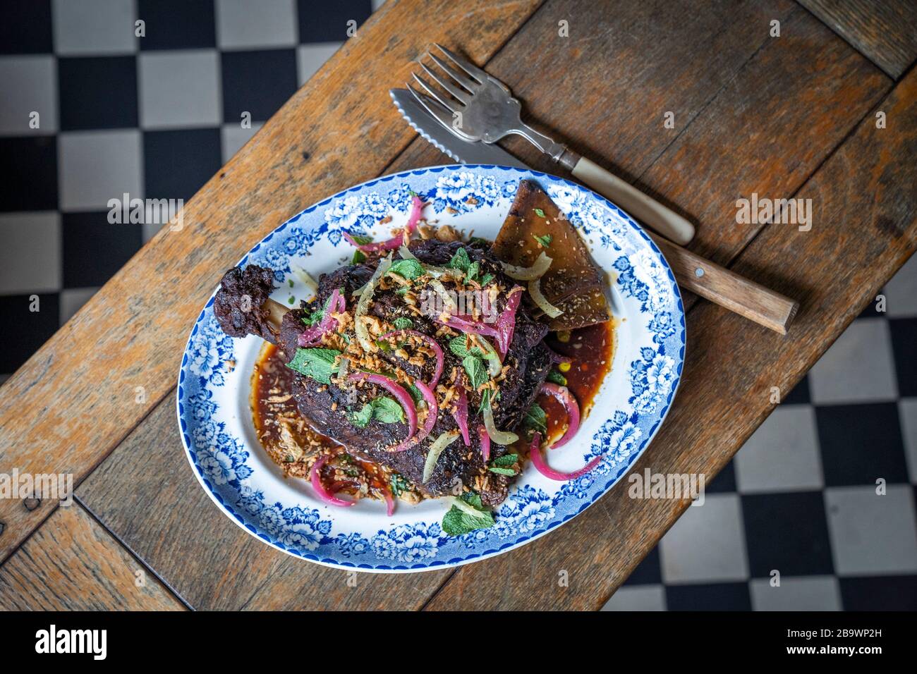 Geräucherte Lammschulter mit Granatapfel, eingelegten Zwiebeln und knusprigen Schalotten Stockfoto