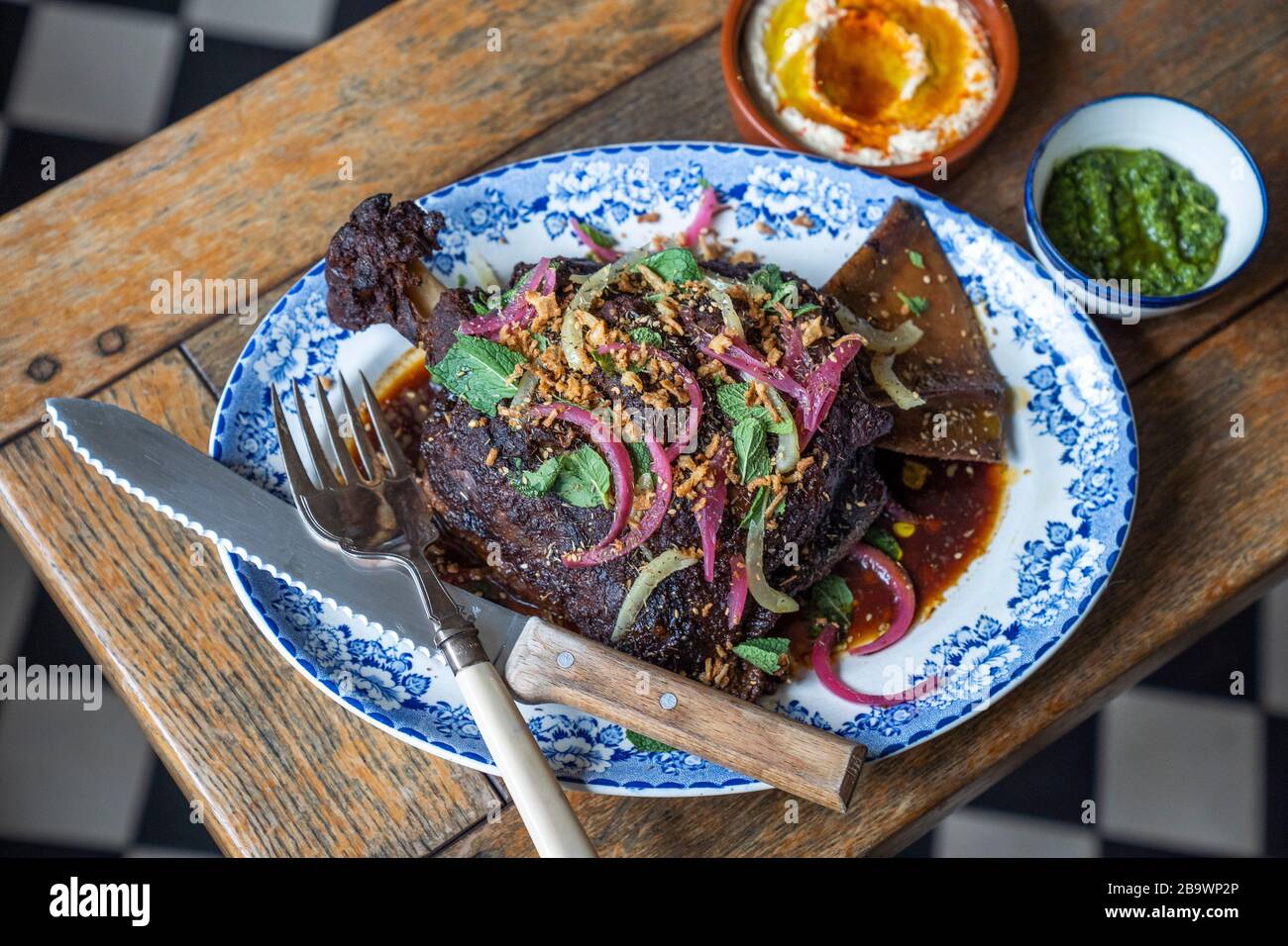 Geräucherte Lamb-Schulter mit eingelegten Zwiebeln, Granatapfel und knusprigen Schalotten Stockfoto