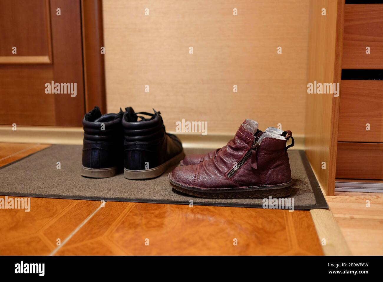 Zwei Paar Schuhe auf einer Türmatte. Schuhe im Flur. Tragekomfort zu Hause. Unterseite, Seitenansicht. Stockfoto