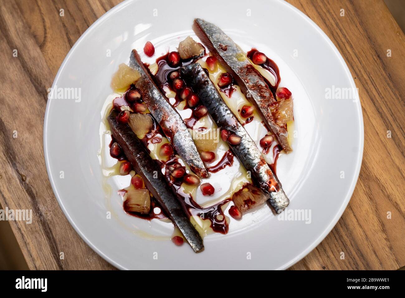Salz gehärtete Sardinen mit Bergamot und Granatapfel Stockfoto