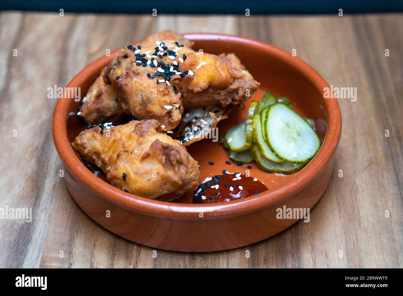 Koreanische Hühnerflügel, fermentierte Chilisauce und eingepickte Gurke Stockfoto
