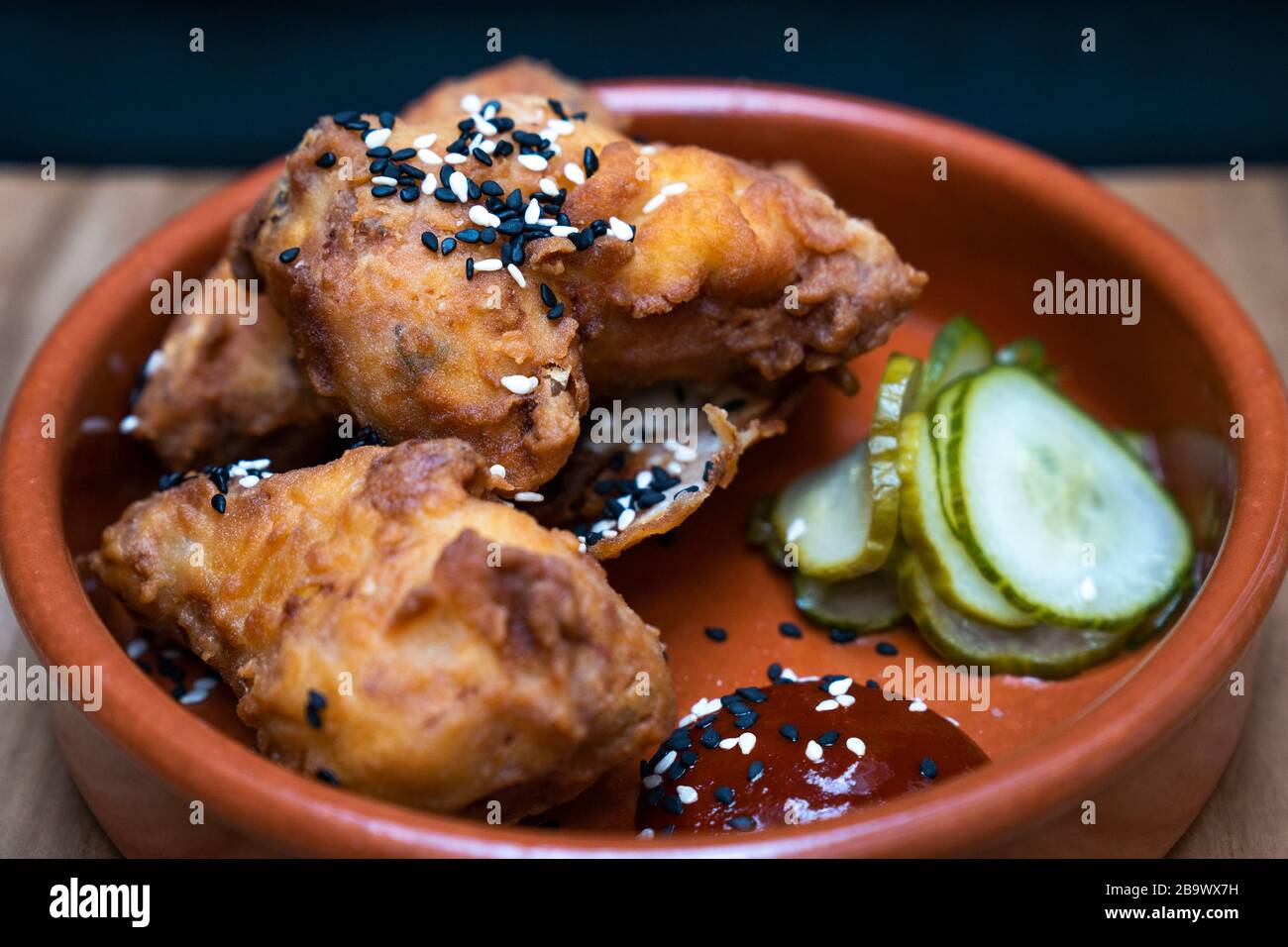 Koreanische Hühnerflügel, fermentierte Chilisauce und eingepickte Gurke Stockfoto