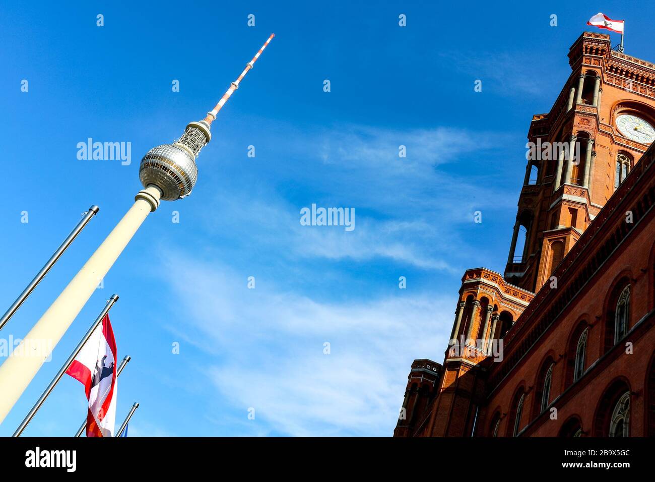 Fernsehturm und Rathaus (deutsch: "Rotes Rathaus") mit schwenkender Berliner Flagge am Alexanderplatz im östlichen Zentrum von Berlin, der Hauptstadt Deutschlands. Stockfoto