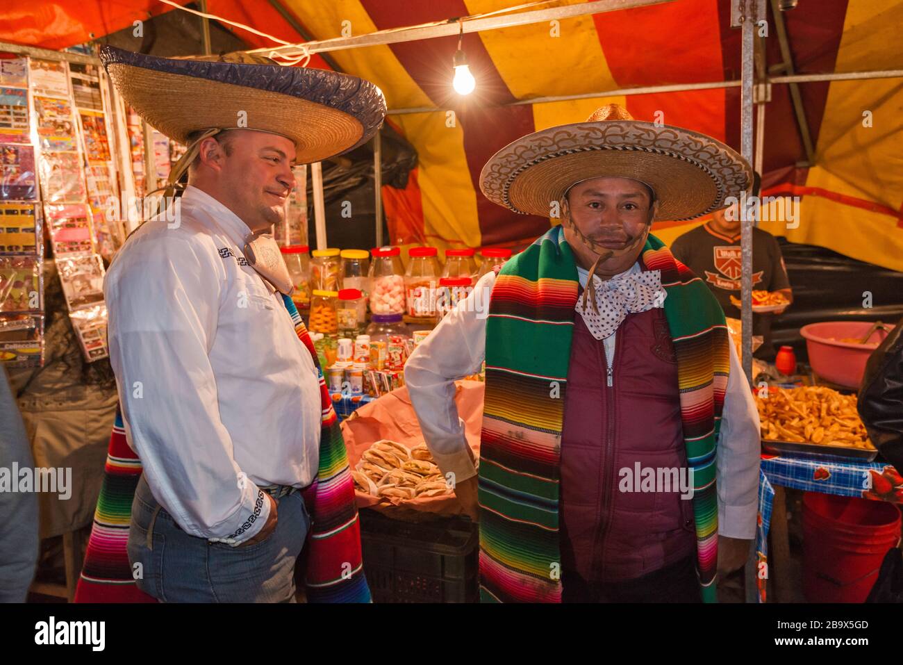 Zwei Männer, die Sombreros tragen, lachen, am Marktstand, Plaza Municipal, Festival unserer Lieben Frau von Guadalupe im Dezember, in Coscomatepec, Bundesstaat Veracruz, Mexiko Stockfoto