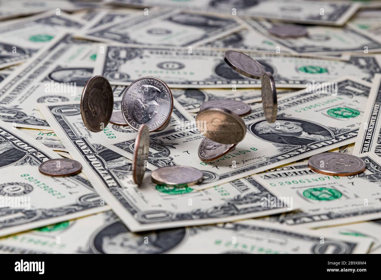 Silbermünzen, die auf US-amerikanische Rechnungen mit einem Dollar fallen. Konzept von Finanzen, Wirtschaft und Wirtschaft Stockfoto