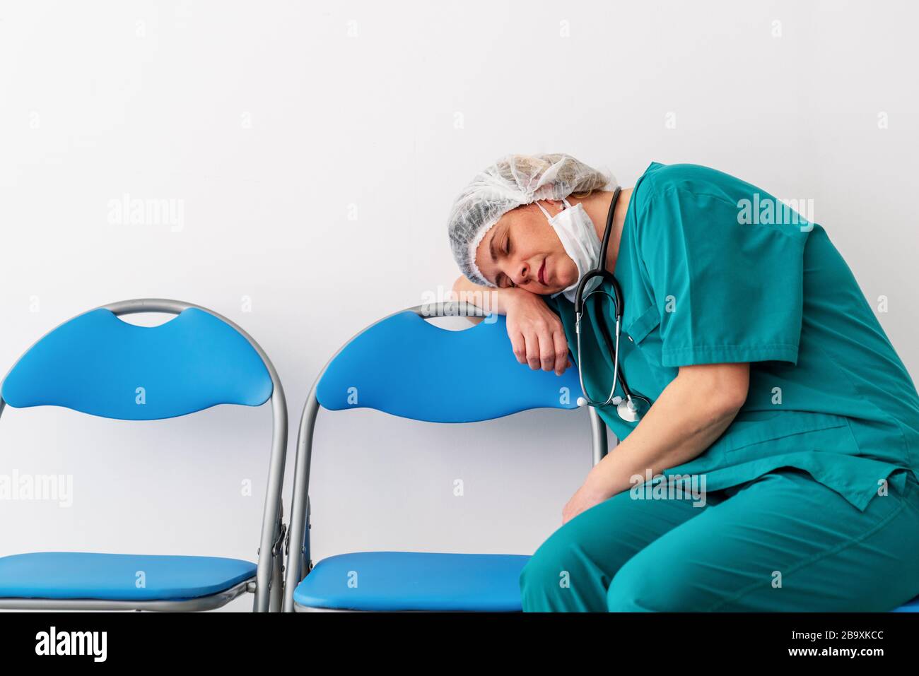 Frau Doktor sitzt und schlief ein, wegen der Sorge, Frustration, Müdigkeit und Erschöpfung der globalen Infektion Kovid 19 Stockfoto