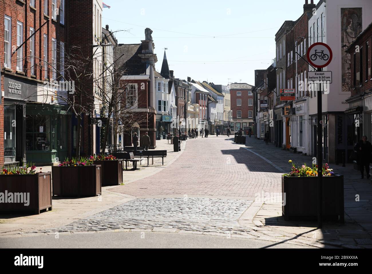 Chichester, Großbritannien. März 2020. Chichester, West Sussex, Großbritannien - die High Street ist leer und verlassen, nachdem die Premierminister Coronavirus (Covid-19) sich absperrten. Die einzigen Personen stehen in der Schlange für Boots Apotheke. Mittwoch, 25. März 2020 Kredit: SAM Stephenson/Alamy Live News Stockfoto