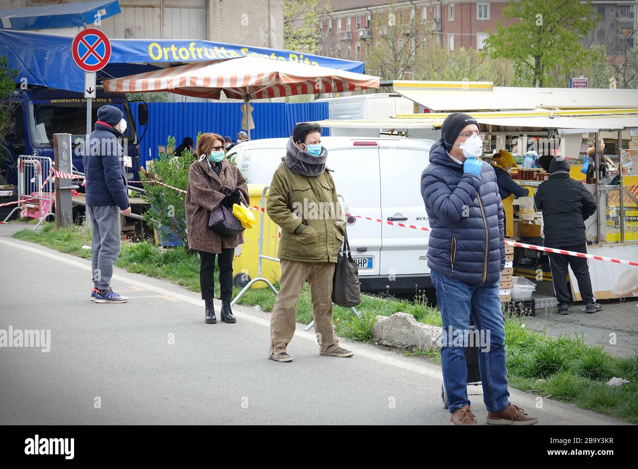 Leute, die Schlange stehen, um einzukaufen, warten auf den Markt im Freien. Soziale Distanzierung. Vorbeugende Maßnahmen. Turin, Italien - März 2020 Stockfoto