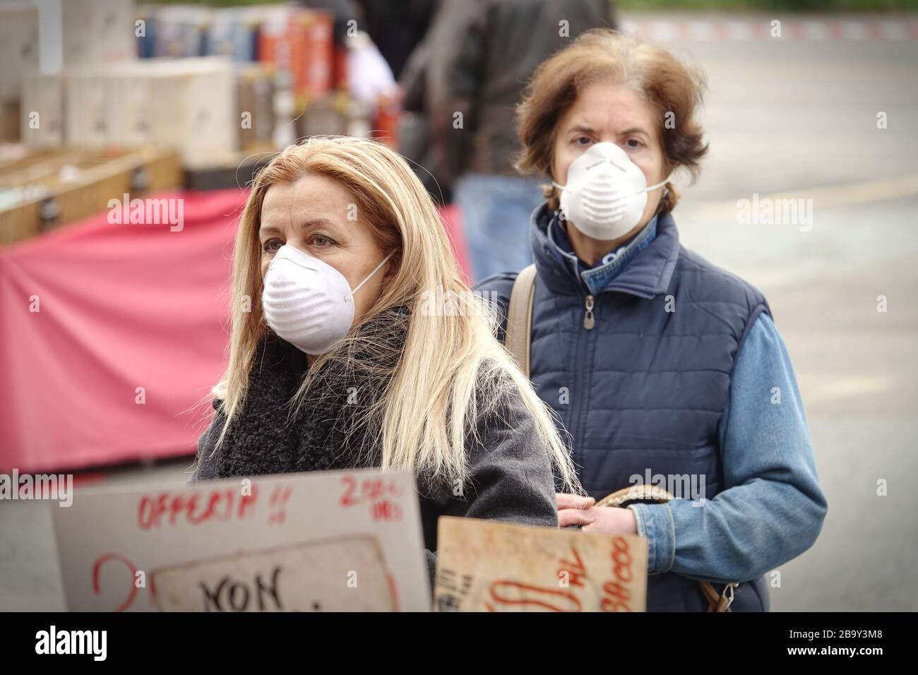 Menschen mit Gesichtsmasken zum Schutz vor COVID-19 kaufen auf dem Markt Gemüse und Obst ein. Turin, Italien - März 2020 Stockfoto