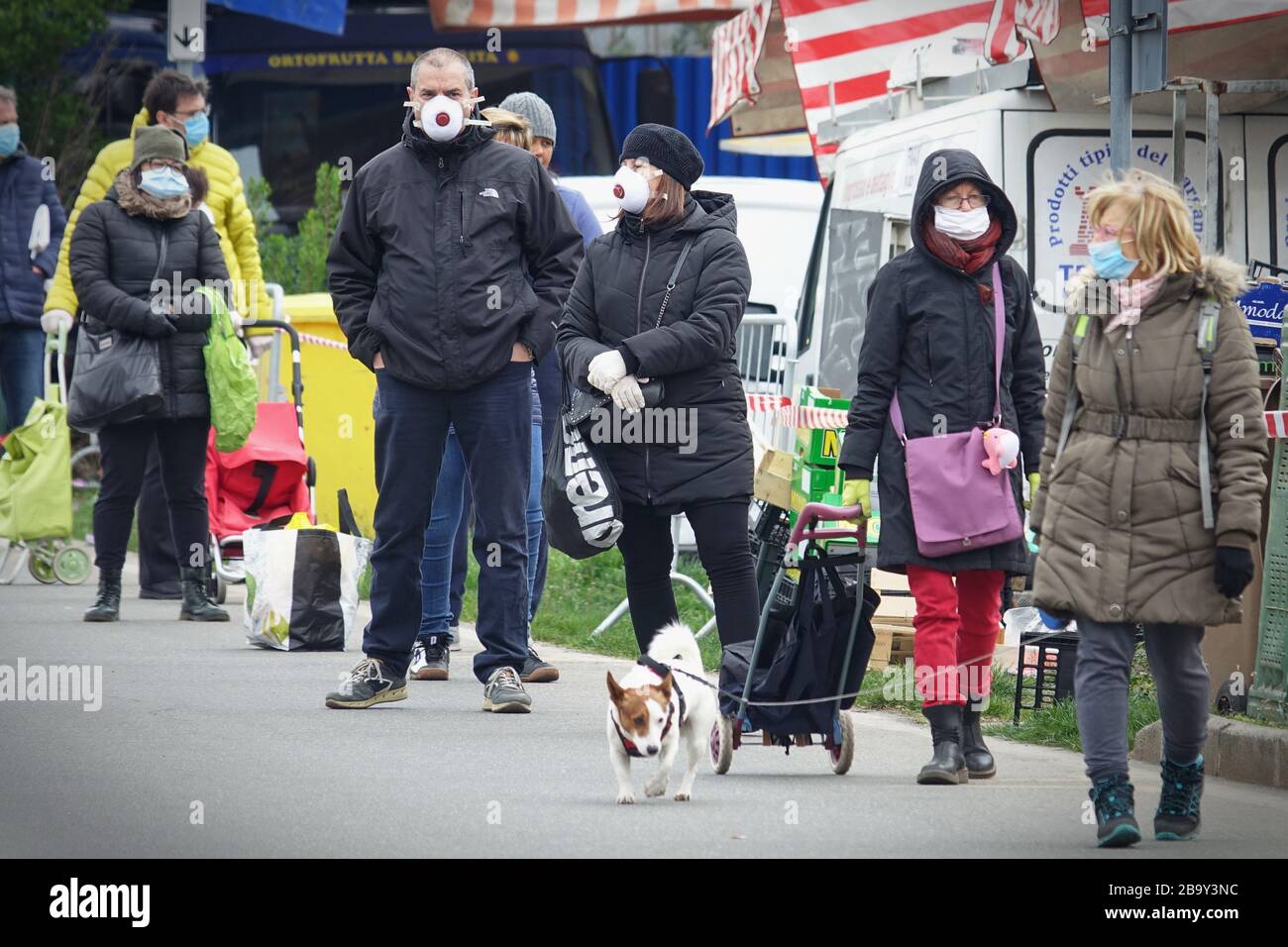 Leute, die Schlange stehen, um einzukaufen, warten auf den Markt im Freien. Soziale Distanzierung. Vorbeugende Maßnahmen. Turin, Italien - März 2020 Stockfoto
