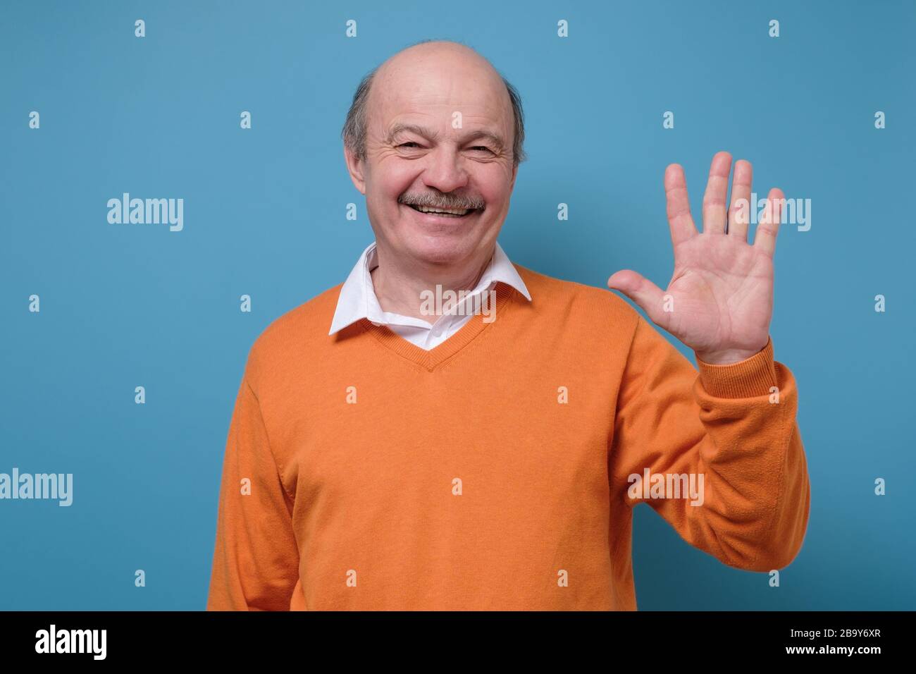Reifer hispanischer Mann winkt Hand seinen Freund willkommen Stockfoto