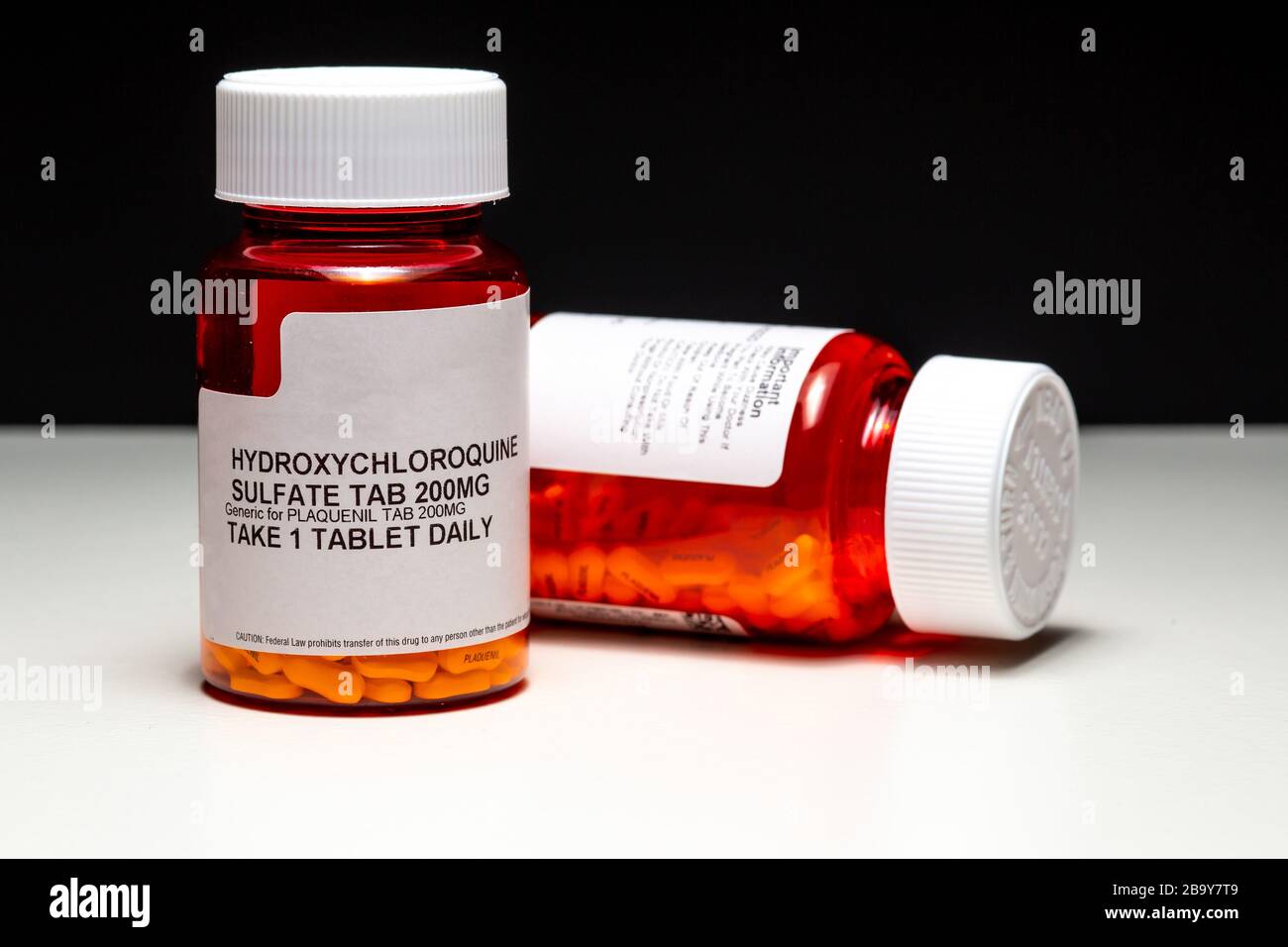 Plaquenil und Hydroxychloroquin (Chloroquin) Pillen, mögliche (unbewiesene) Behandlung gegen COVID-19 vor Split White und Black Background Stockfoto