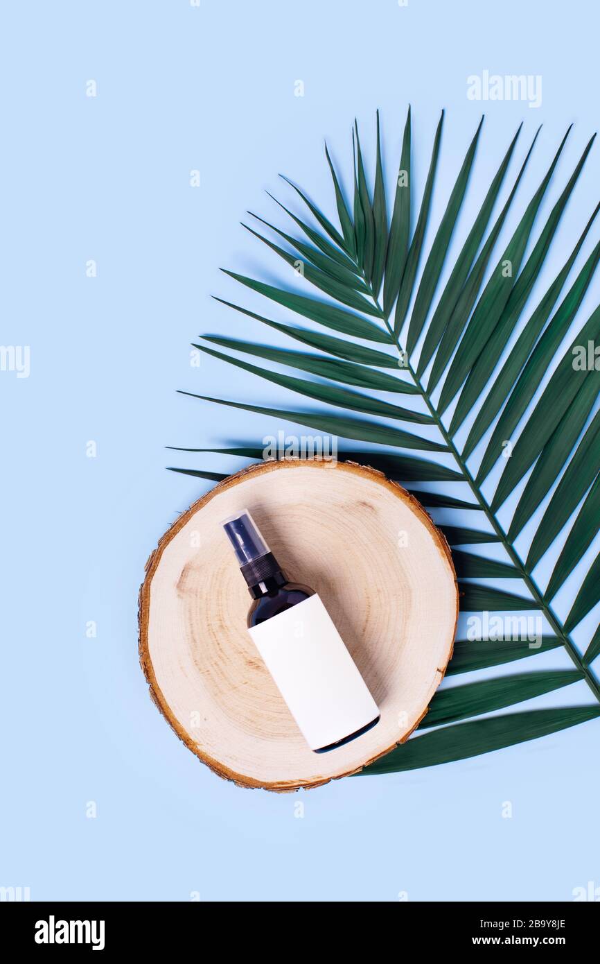 Werbebild. Glassprühflasche auf blauem Hintergrund, umgeben von Lavendel. Stockfoto